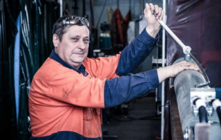 Maintenance man with wrench working on hydraulics